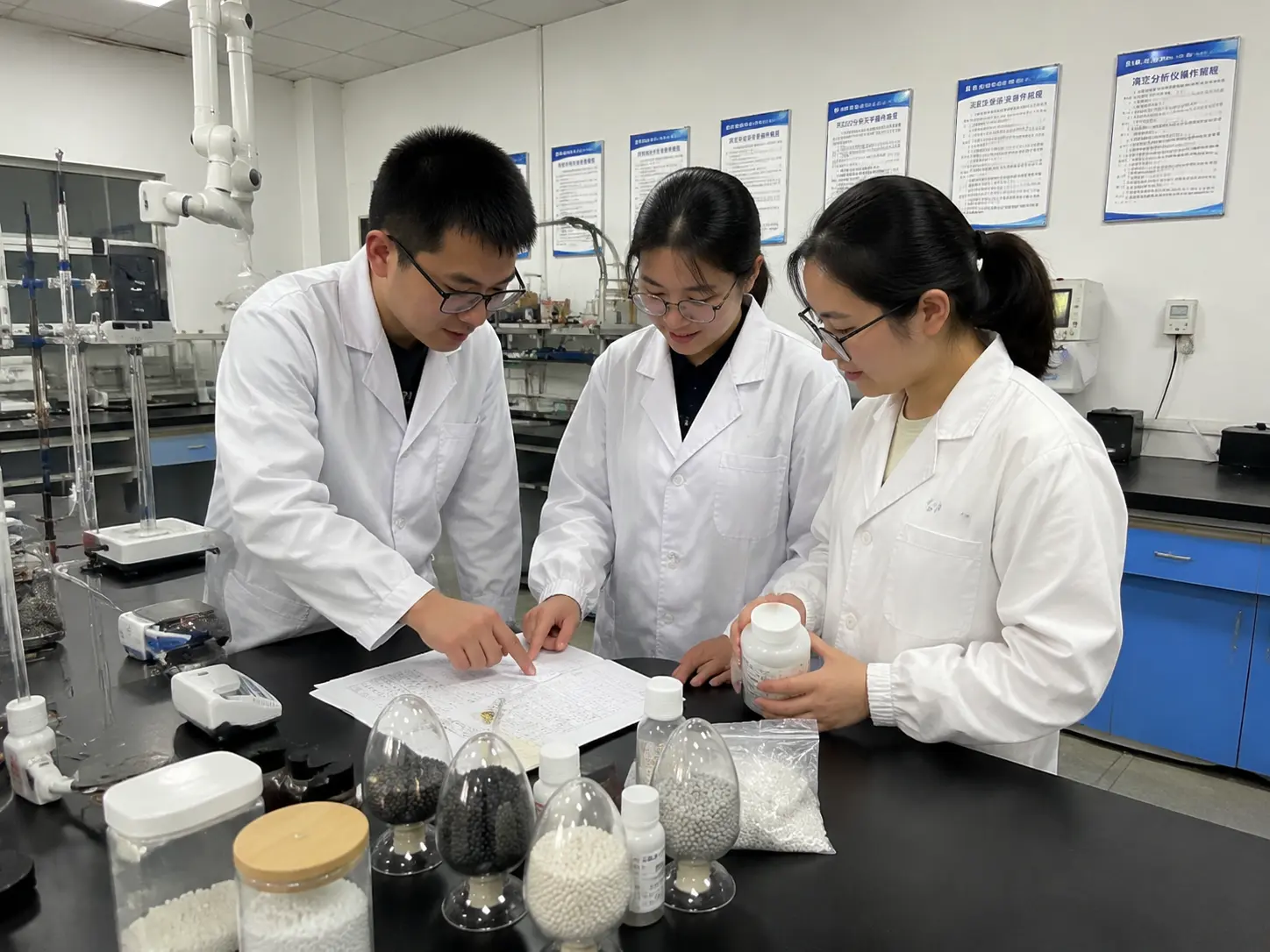 R&D technicians discussing a flame retardant formulation sheet in the lab