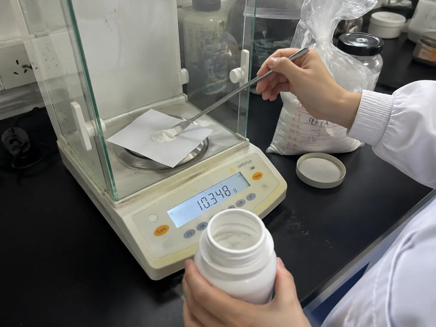 Technician weighing raw material on a digital lab scale