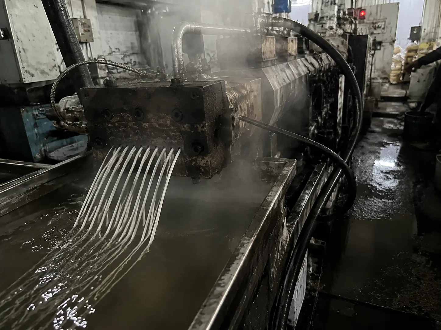 Polymer strands leaving the twin-screw extruder during a flame retardant polyethylene trial batch